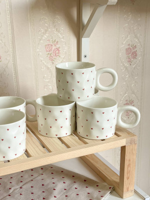 كوب مع يد دائرية وقلوب صغيرة