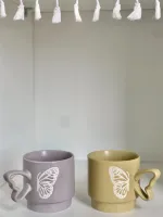 كوب مع يد فراشة