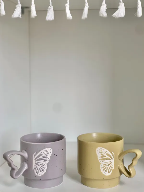 كوب مع يد فراشة