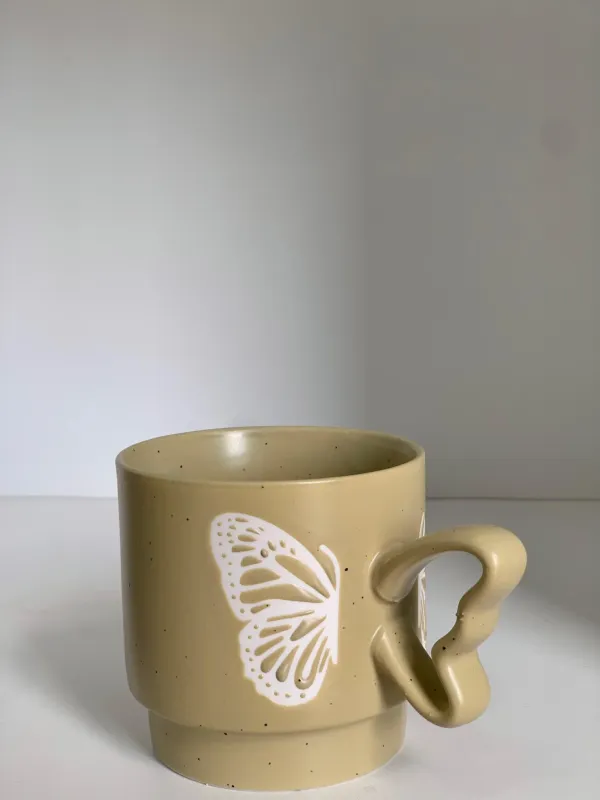 كوب مع يد فراشة