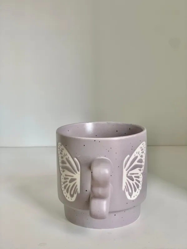 كوب مع يد فراشة