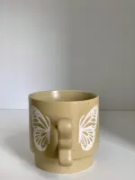كوب مع يد فراشة