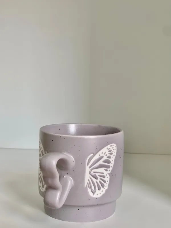 كوب مع يد فراشة