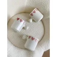 كوب أبيض قلوب مع يد غريبة