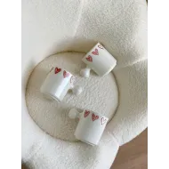 كوب أبيض قلوب مع يد غريبة