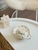فنجان أبيض مع قلوب ملونة-