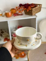 فنجان أبيض مع رسمات ورد بارزة