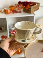 فنجان لون بيج مع صحن رسمات أحفورات