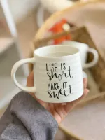 كوب أبيض مع عبارات